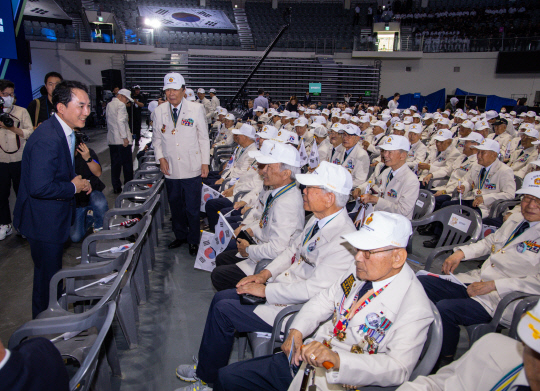 박민식 국가보훈부 장관이 25일 오전 서울 중구 장충체육관에서 열린 6.25 73주년 행사에 참석해 올해 행사부터 지급된 '영웅의 제복'을 입은 6.25 참전 용사들에게 인사하고 있다.  연합뉴스